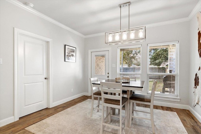 dining area with wood-type flooring and crown molding