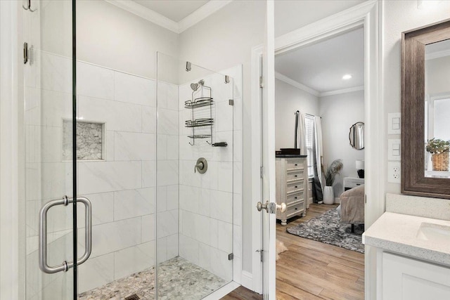 bathroom featuring hardwood / wood-style floors, vanity, an enclosed shower, and ornamental molding