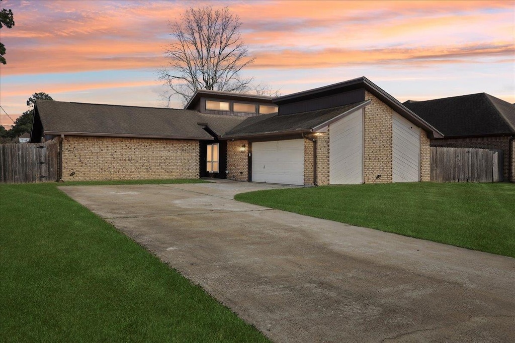 view of front of house featuring a garage and a lawn