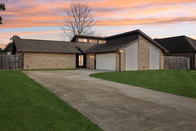 view of front of house featuring a garage and a lawn