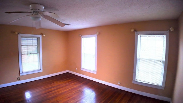 unfurnished room with dark wood-type flooring, a textured ceiling, baseboards, and a ceiling fan