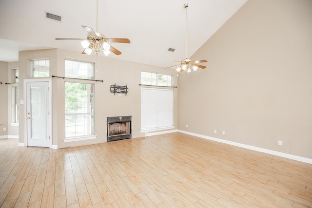 unfurnished living room featuring ceiling fan, high vaulted ceiling, and light wood-type flooring