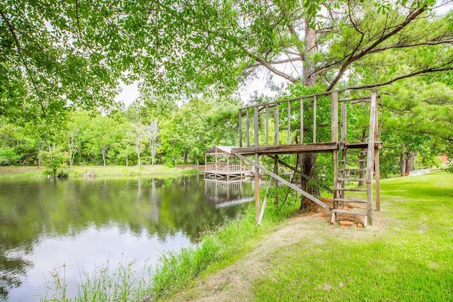 dock area with a lawn and a water view