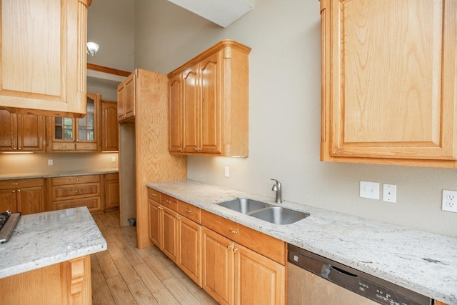 kitchen featuring dishwasher, sink, light stone countertops, and light wood-type flooring