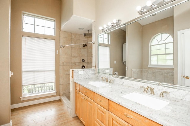 bathroom featuring tiled shower, vanity, and hardwood / wood-style flooring