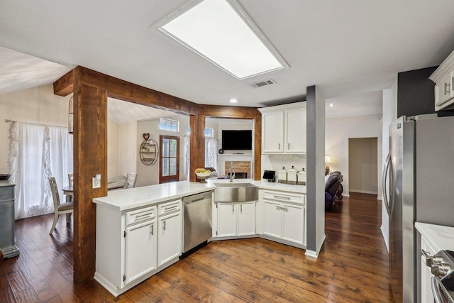 kitchen featuring stainless steel appliances, dark wood-style floors, a sink, visible vents, and light countertops