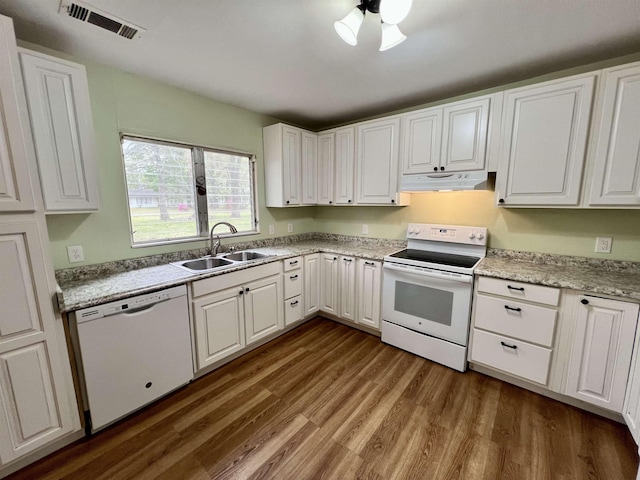 kitchen featuring dark wood-type flooring, under cabinet range hood, white appliances, white cabinetry, and a sink