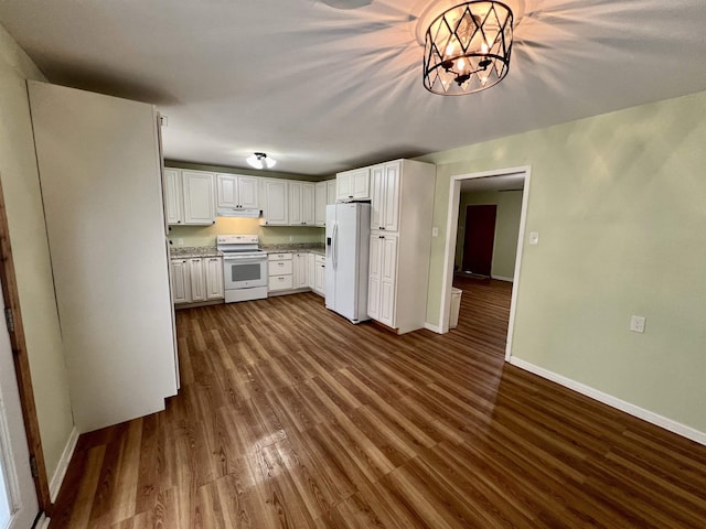 kitchen with white appliances, baseboards, dark wood-style flooring, under cabinet range hood, and white cabinetry