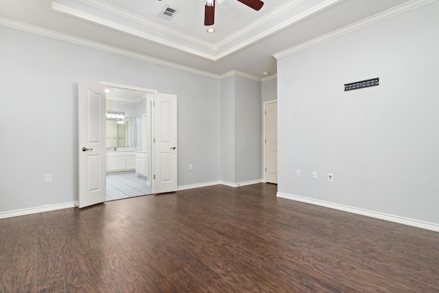 spare room with a raised ceiling, crown molding, hardwood / wood-style floors, and ceiling fan