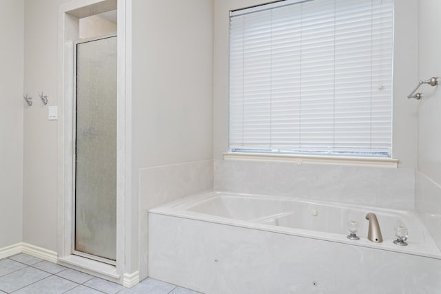 bathroom with a wealth of natural light, tile patterned floors, and separate shower and tub