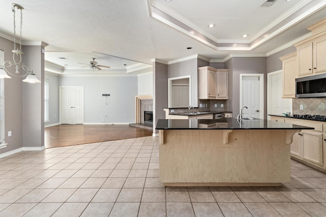 kitchen featuring light tile patterned floors, a kitchen breakfast bar, and a raised ceiling