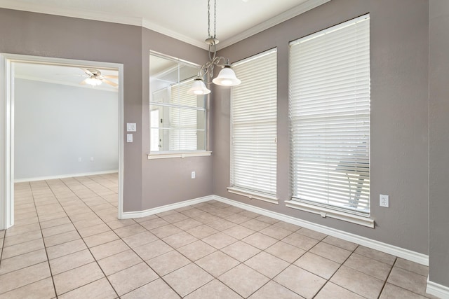 unfurnished dining area featuring ceiling fan with notable chandelier, a wealth of natural light, ornamental molding, and light tile patterned flooring