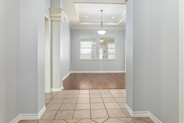 interior space featuring light tile patterned flooring, ornamental molding, and a raised ceiling