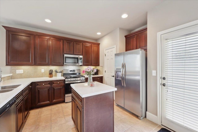 10375 Dominion Ct, Port Arthur, TX 77640 - kitchen with appliances with stainless steel finishes, light countertops, a kitchen island, a sink, and decorative backsplash