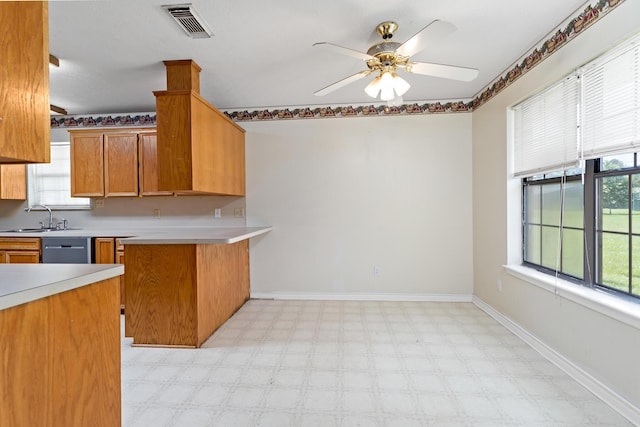 kitchen featuring kitchen peninsula, a wealth of natural light, sink, and ceiling fan