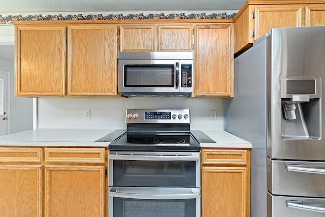 kitchen featuring light brown cabinetry and stainless steel appliances