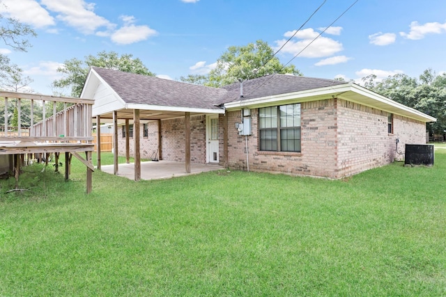 rear view of property with a lawn, a patio, and central AC unit