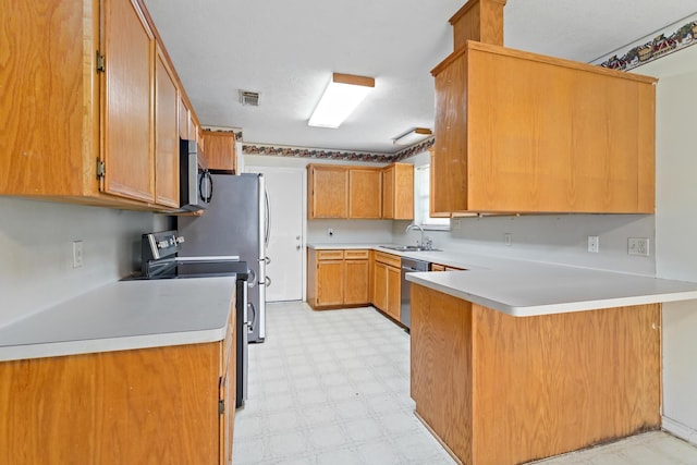 kitchen with kitchen peninsula, sink, and appliances with stainless steel finishes