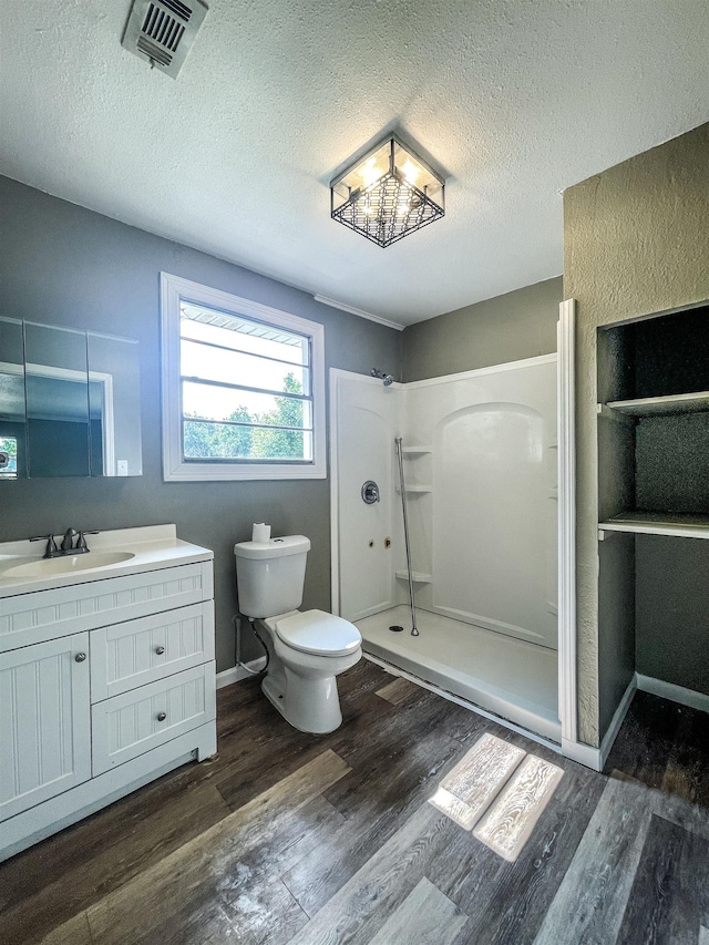 1510 S Timberlane St, Vidor, TX 77662 - bathroom with wood finished floors, a walk in shower, a textured ceiling, and vanity