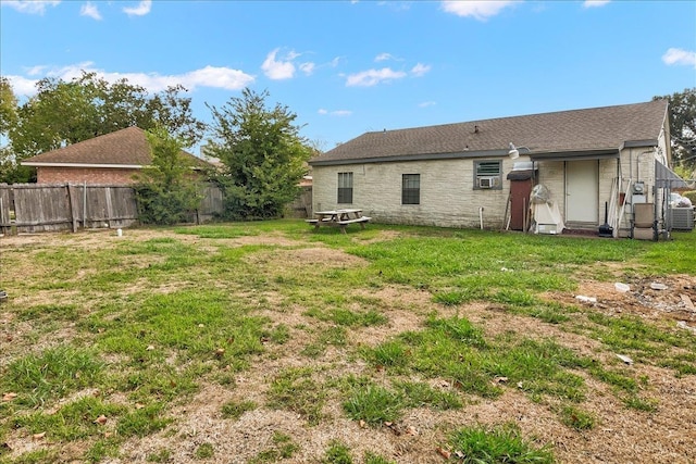 rear view of property featuring a lawn