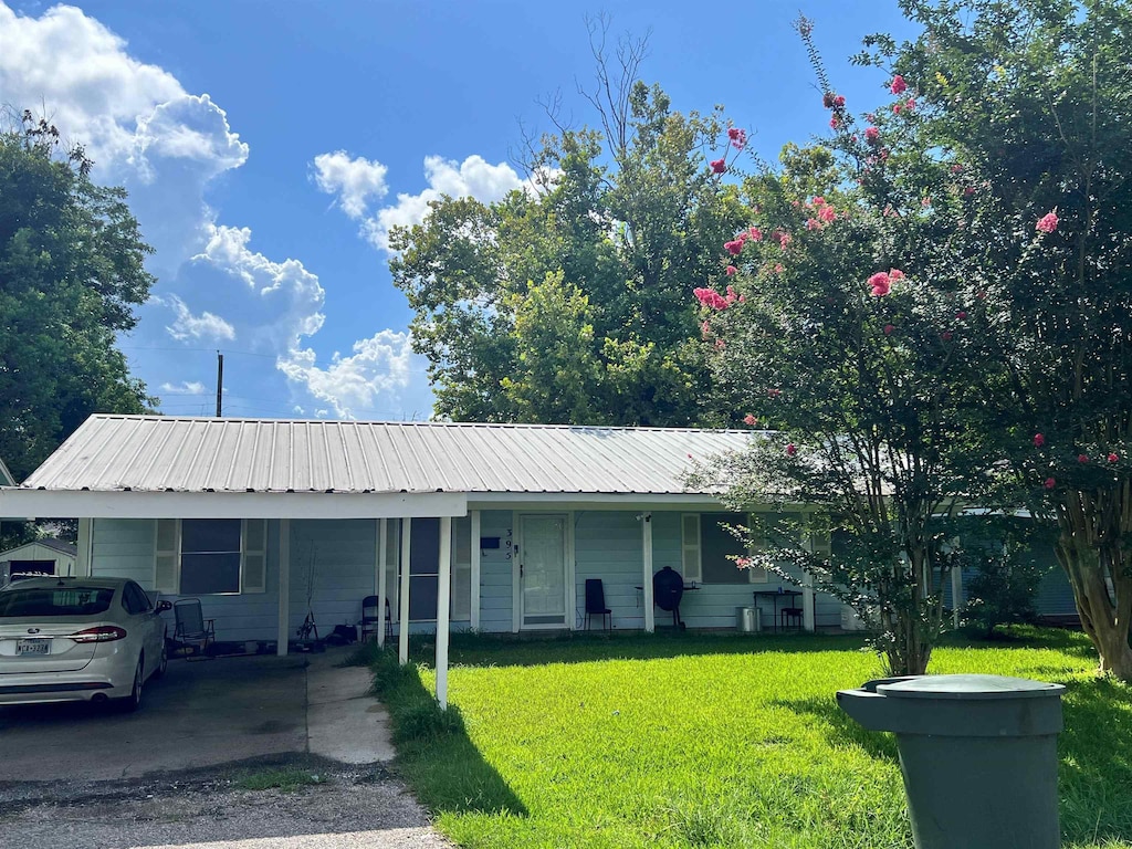 395 Clemmons St, Beaumont, TX 77707 - view of front of home with a carport, a front yard, and a metal roof