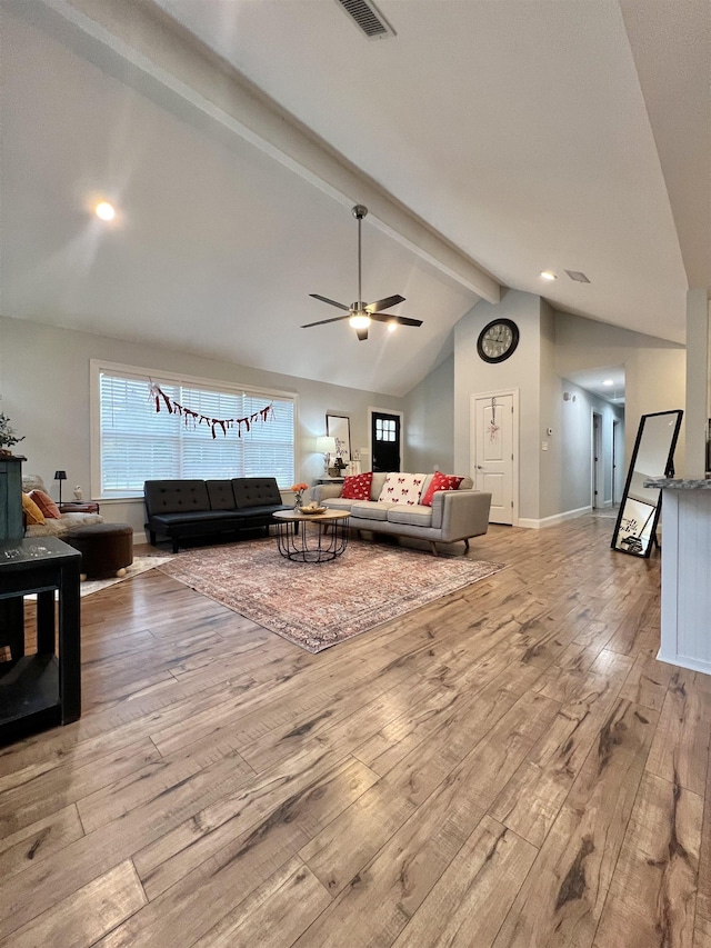 living room featuring lofted ceiling with beams, light hardwood / wood-style floors, and ceiling fan