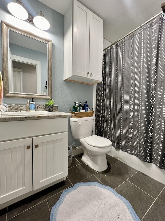 bathroom featuring tile patterned flooring, vanity, walk in shower, and toilet