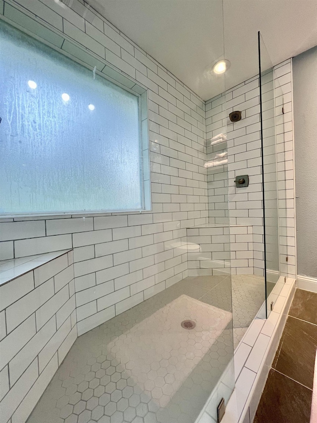 bathroom featuring a tile shower and tile patterned floors