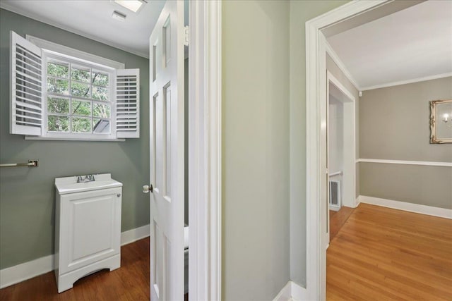 623 20th St, Beaumont, TX 77706 - bathroom with ornamental molding, wood finished floors, baseboards, and a sink