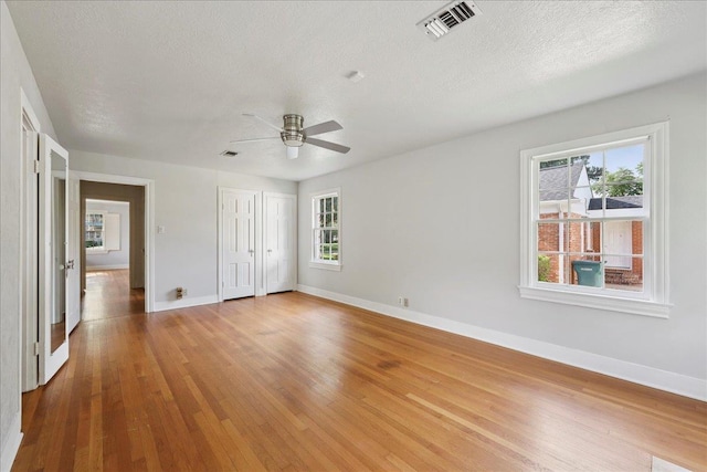 623 20th St, Beaumont, TX 77706 - unfurnished bedroom with baseboards, wood finished floors, a textured ceiling, a closet, and ceiling fan