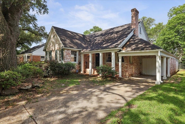 623 20th St, Beaumont, TX 77706 - view of front of house with brick siding, a chimney, an attached carport, driveway, and roof with shingles