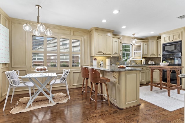 880 Goodhue Rd, Beaumont, TX 77706 - kitchen with cream cabinetry, black appliances, dark wood-style floors, tasteful backsplash, and a peninsula