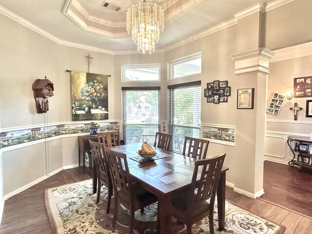 dining space featuring a chandelier, ornamental molding, dark wood-type flooring, and a tray ceiling