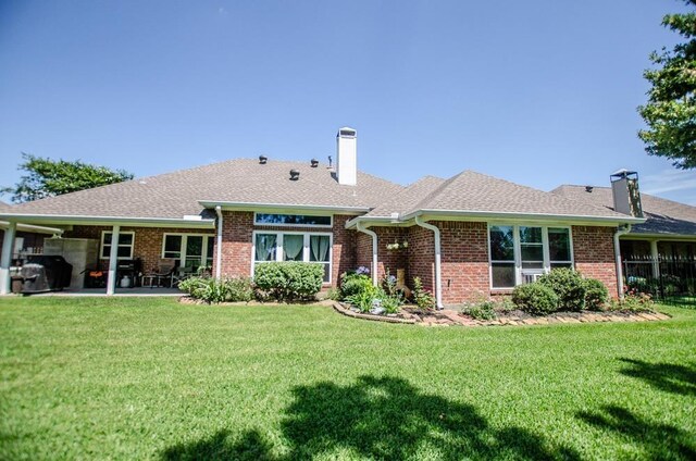 rear view of property with a patio area and a yard