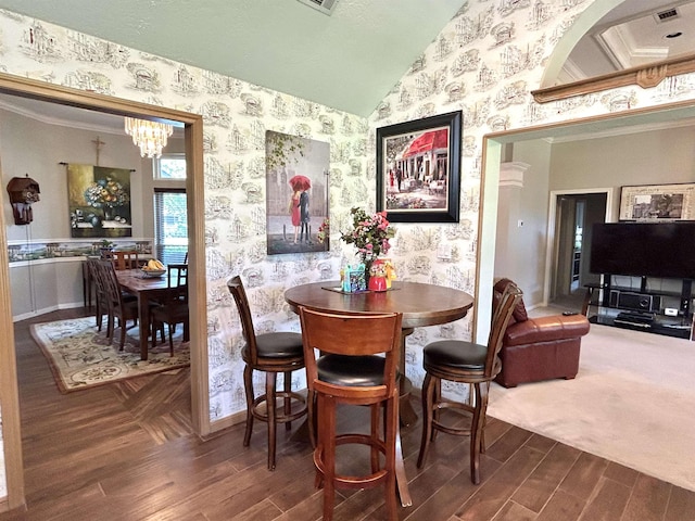 dining space with vaulted ceiling, dark hardwood / wood-style flooring, crown molding, and a chandelier