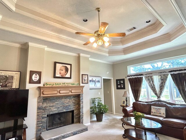 living room featuring carpet flooring, crown molding, a raised ceiling, and a fireplace