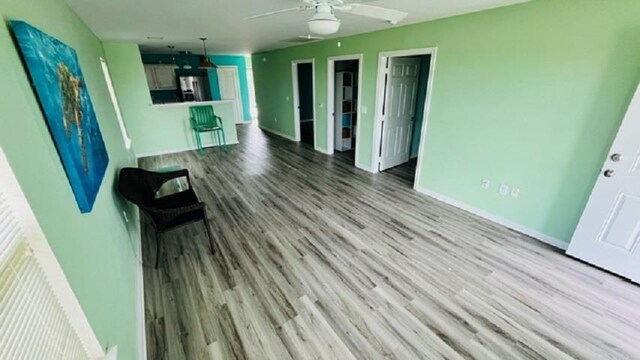 unfurnished living room with light hardwood / wood-style flooring and ceiling fan