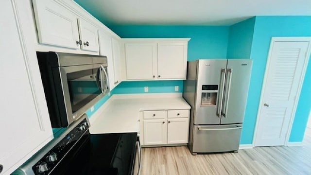 kitchen with white cabinetry, light wood-type flooring, and appliances with stainless steel finishes