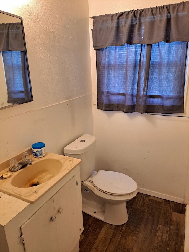 bathroom with hardwood / wood-style floors, vanity, and toilet