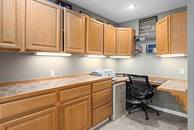 office featuring light tile patterned floors and built in desk