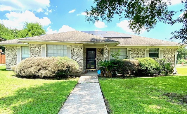 view of front of house featuring a front lawn and solar panels