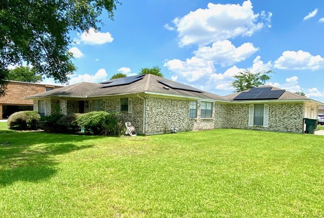 view of property exterior with a yard and solar panels