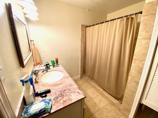 bathroom with tile patterned flooring, vanity, curtained shower, and a textured ceiling