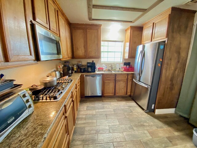 kitchen featuring light stone counters, sink, and appliances with stainless steel finishes