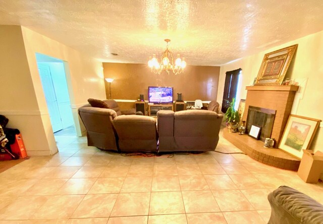 tiled living room featuring an inviting chandelier, a textured ceiling, and a brick fireplace