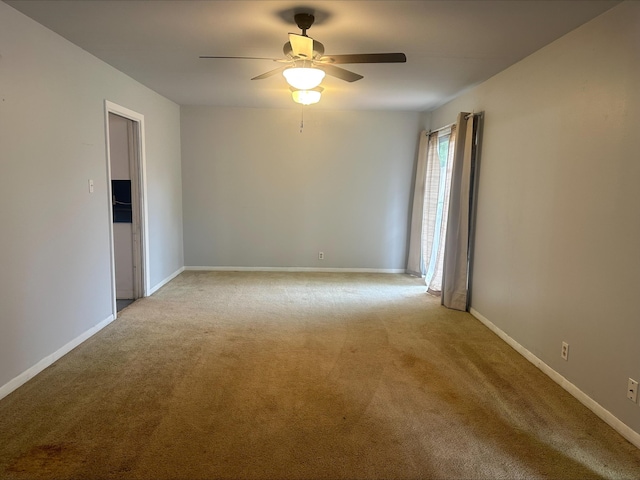 unfurnished room featuring light colored carpet, baseboards, and ceiling fan