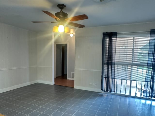 unfurnished room featuring baseboards, a ceiling fan, and visible vents