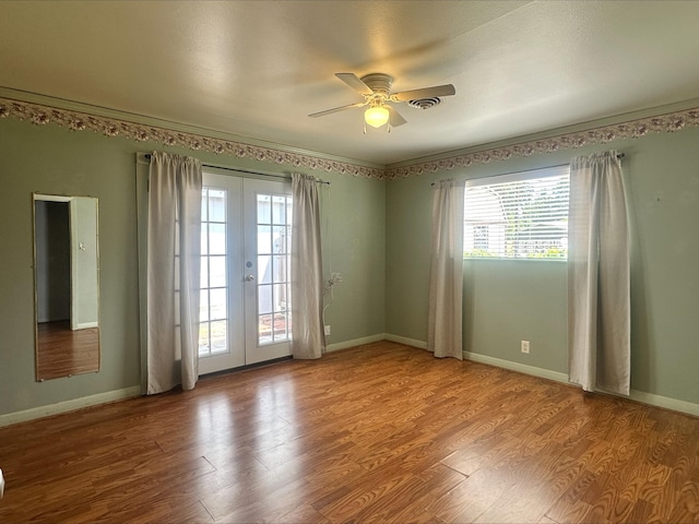 spare room featuring a ceiling fan, visible vents, french doors, and wood finished floors