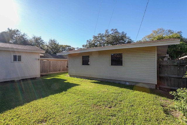 4612 Redbird St, Port Arthur, TX 77642 - rear view of property with an outbuilding, a lawn, and fence