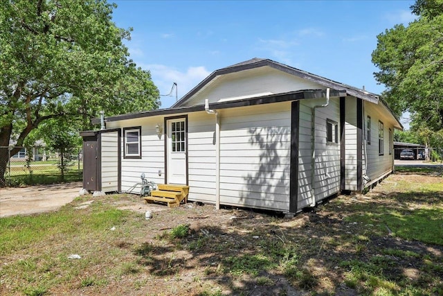 back of house featuring fence and entry steps